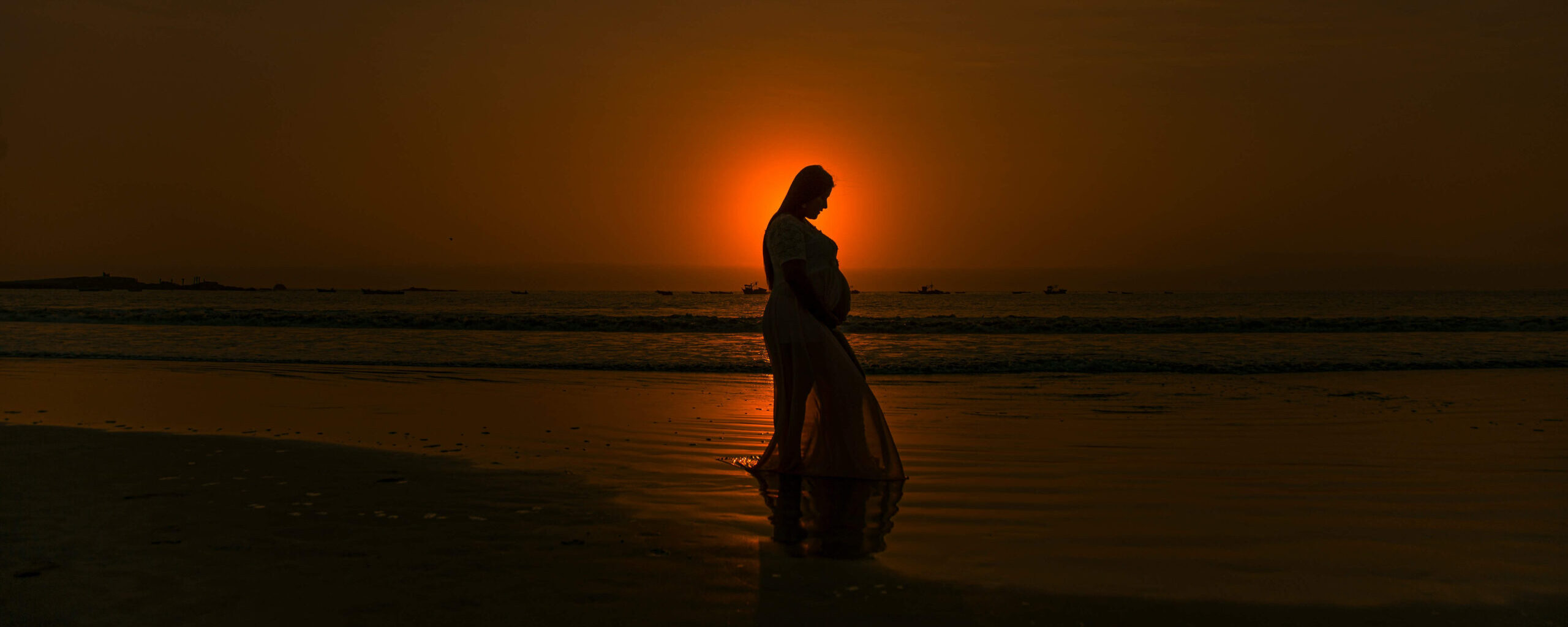 silhouette-of-pregnant-person-standing-on-beach-during-sunset-by_Oscar-Leon Sonnenuntergang hinter schwangerer Frau am Strand als Symbol für die mütterliche Verbindung zu den verstorbenen Kindern ins Jenseits